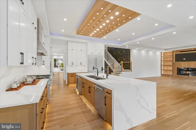 a large kitchen with stainless steel appliances a large counter top a stove and a sink