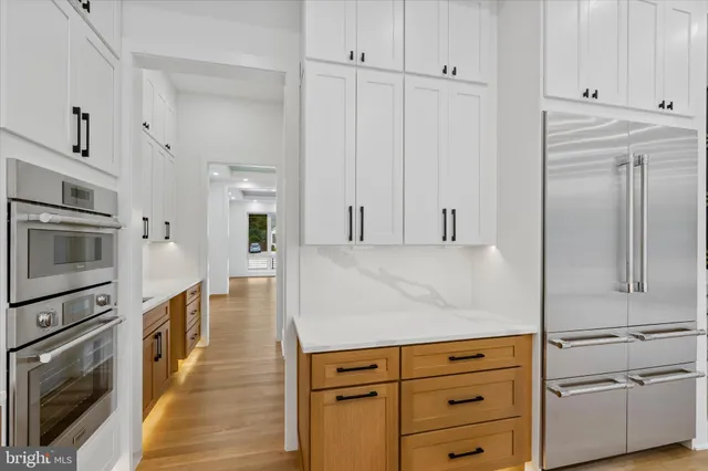 a kitchen with granite countertop white cabinets and stainless steel appliances