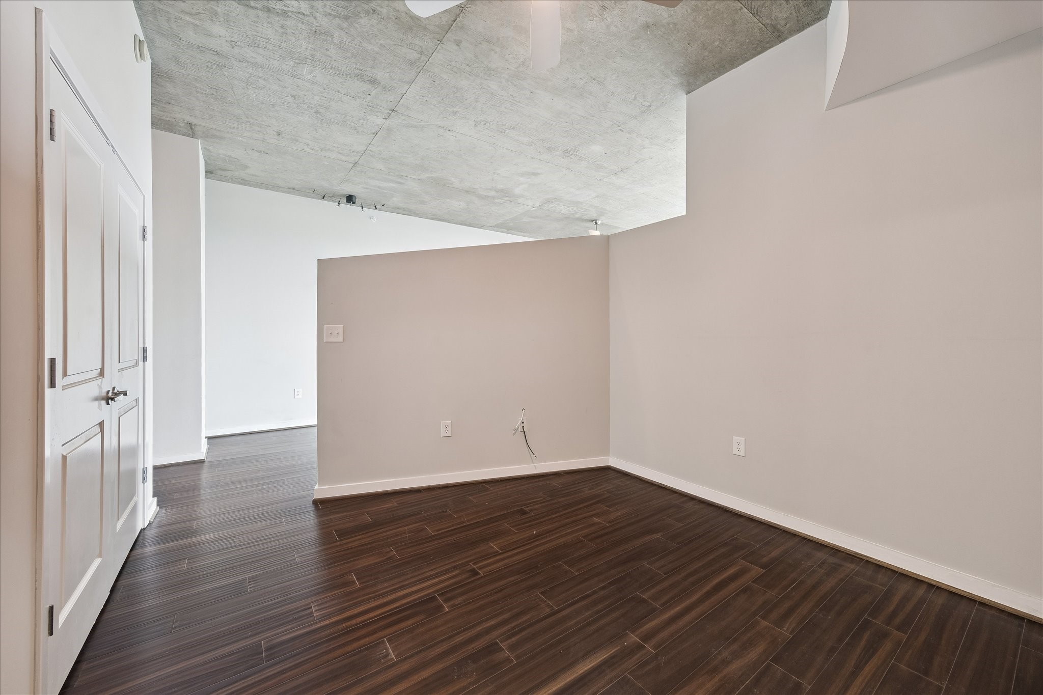 Private bedroom retreat with modern loft styling, engineered hardwood flooring, ceiling fan, and convenient access to the main living areas.