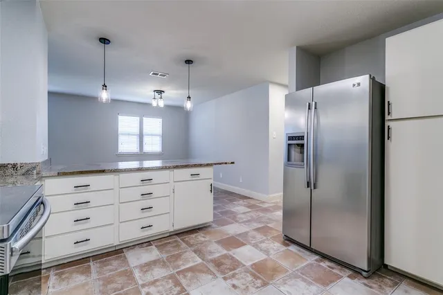 a kitchen with white cabinets and refrigerator
