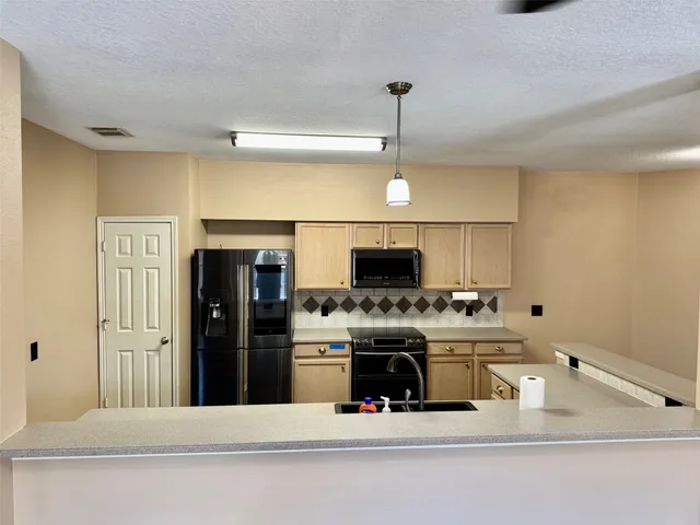 a kitchen with kitchen island stainless steel appliances a sink stove and refrigerator