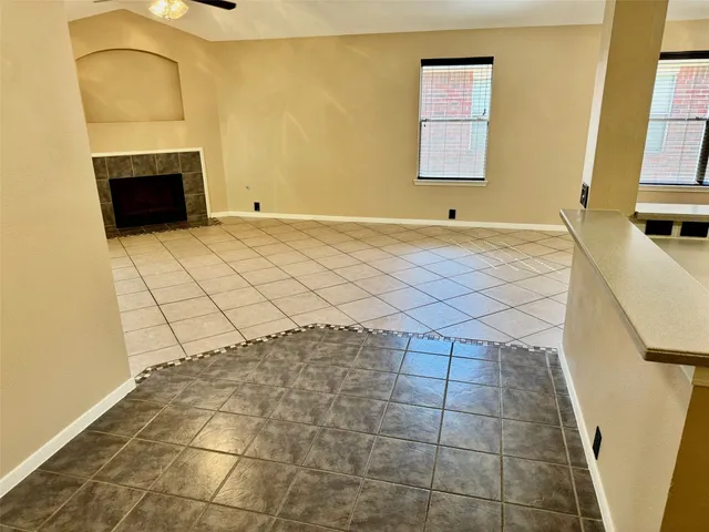 an empty room with wooden floor and fan