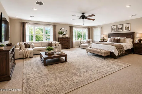 a spacious bedroom with a bed couch and windows