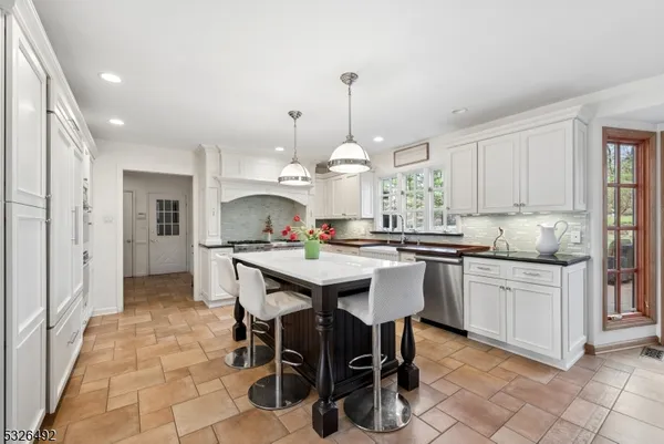 a kitchen with kitchen island granite countertop a sink and white cabinets