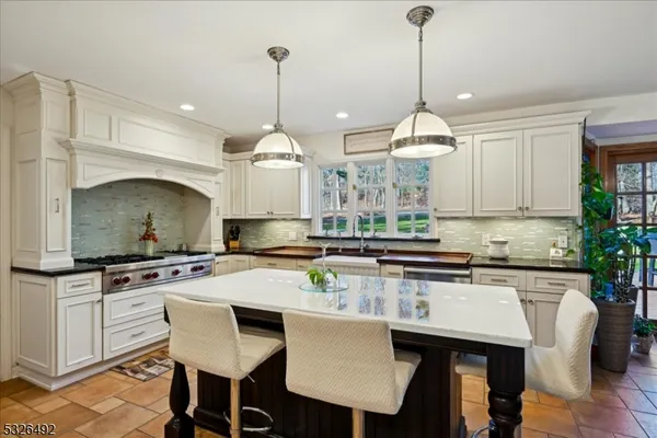 a kitchen with stainless steel appliances a stove a sink a table and chairs