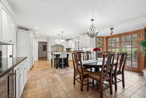 a dining room with furniture a chandelier and kitchen view