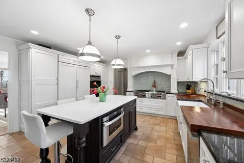 a kitchen with a dining table cabinets a sink and appliances