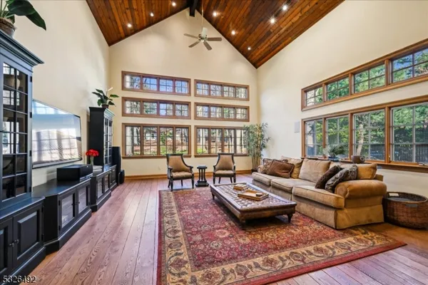 a living room with furniture large window and wooden floor