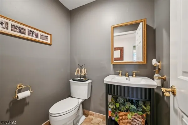 a bathroom with a toilet a sink and mirror