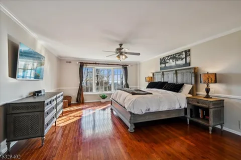 a spacious bedroom with a bed and wooden floor