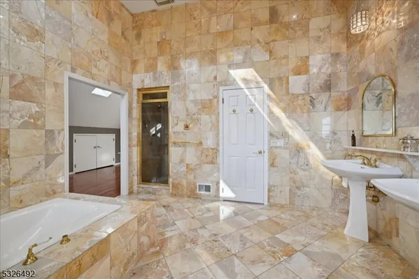 a view of a bathroom with bathtub and shower