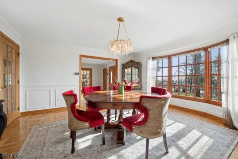 a dining room with furniture a chandelier and wooden floor