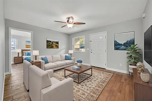 a living room with furniture potted plant and wooden floor