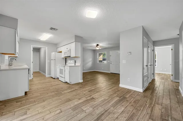 a view of a kitchen with wooden floor and a large window