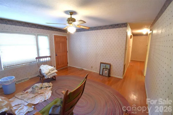 a view of a livingroom with furniture and chandelier fan