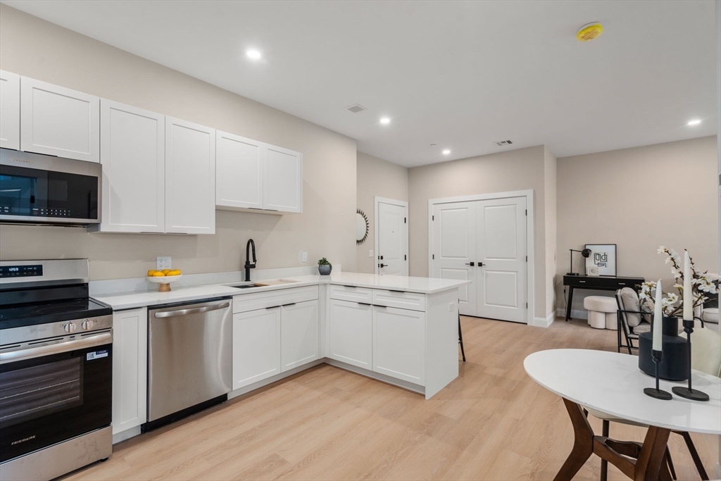 7 Cross Street, Unit 306 Wilmington, MA 01887 - Photo 8 of 14 a kitchen with a sink white cabinets and stainless steel appliances