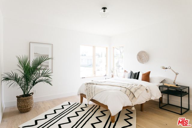a bedroom with a bed and a potted plant