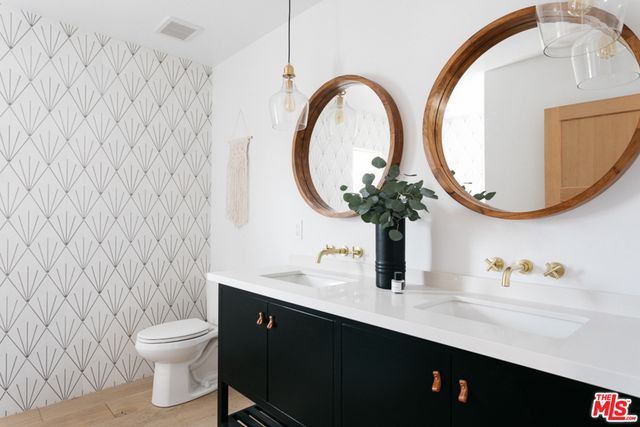 a bathroom with a granite countertop toilet sink and mirror