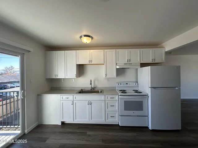 a kitchen with stainless steel appliances a sink a stove a refrigerator and cabinets