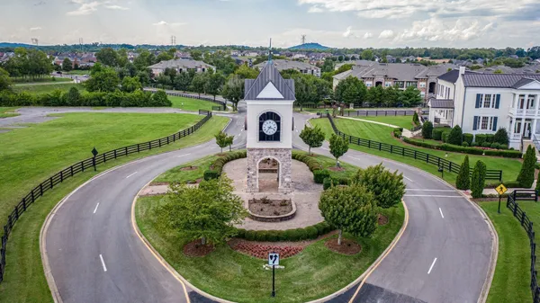 an aerial view of a house with a big yard and large trees