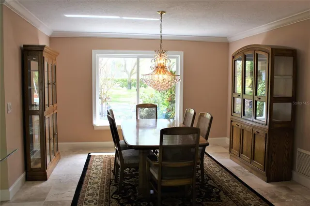 a dining room with furniture a chandelier and wooden floor