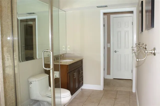 a bathroom with a granite countertop sink a toilet and shower