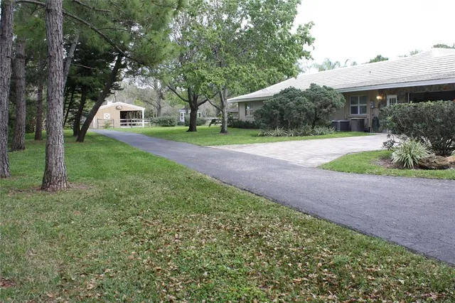 a front view of a house with a yard and trees
