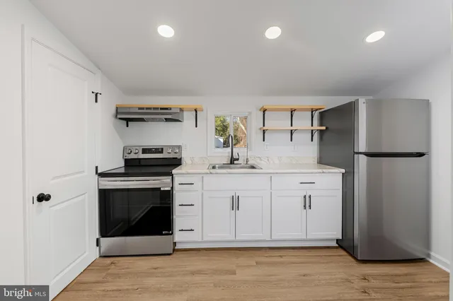 a kitchen with stainless steel appliances a stove sink and cabinets