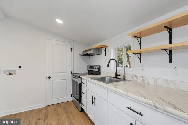 a kitchen with stainless steel appliances granite countertop a sink and wooden cabinets