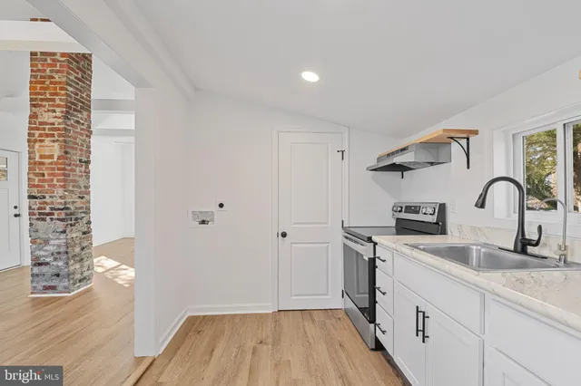 a kitchen with granite countertop a white stove top oven and sink