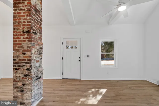a view of a room has a window and wooden floor