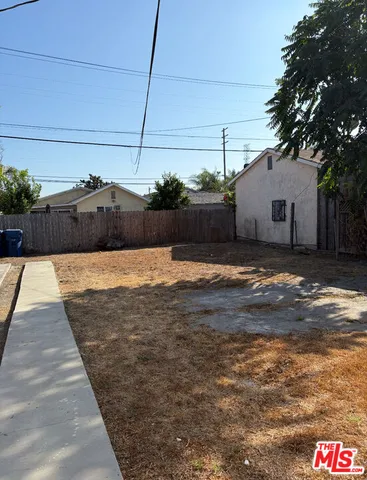 a swimming pool with yard and tree in front of it