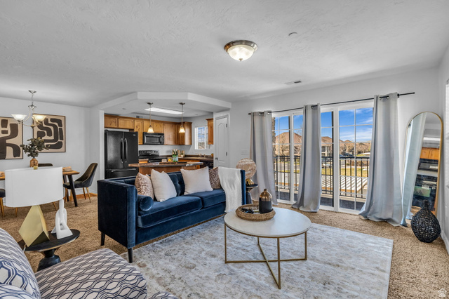1136 West Spencer Road, Unit Y203 Pleasant Grove, UT 84062 - Photo 5 of 26 Living room with light carpet and hanging lights