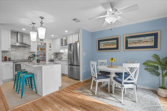a view of a dining room with furniture and a chandelier fan