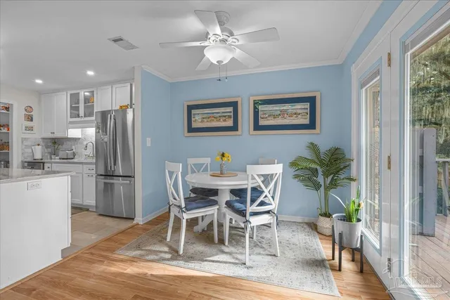 a view of a dining room with furniture and a kitchen view