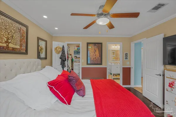 a bedroom with a large bed and a chandelier