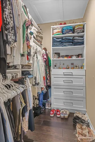 a view of walk in closet with clothes and shoes