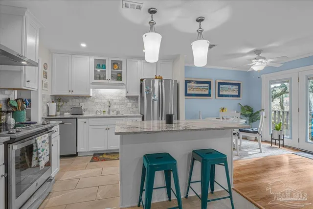 a kitchen with cabinets a sink stainless steel appliances and dining table