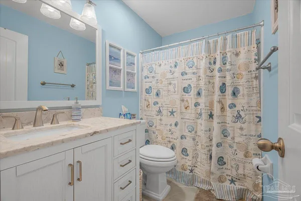 a bathroom with a granite countertop sink a toilet and a mirror