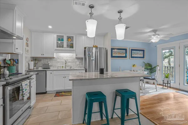 a kitchen with cabinets a sink stainless steel appliances and dining table