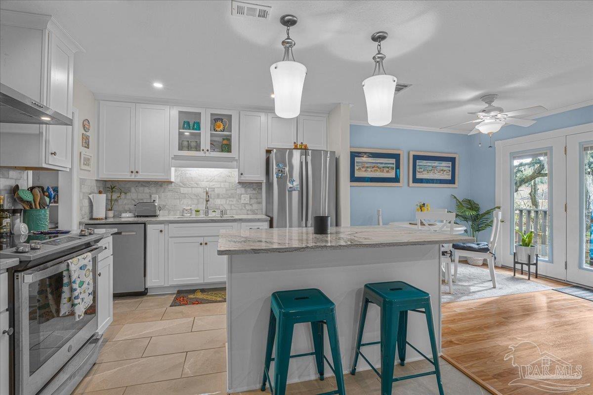 4831 East Olive Road, Unit 1D Pensacola, FL 32514 - Photo 3 of 36 a kitchen with cabinets a sink stainless steel appliances and dining table