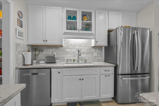 a kitchen with stainless steel appliances granite countertop a refrigerator and a sink