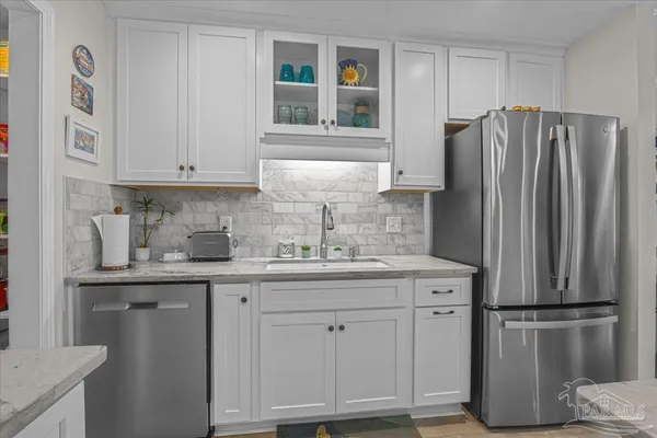 a kitchen with stainless steel appliances granite countertop a refrigerator and a sink