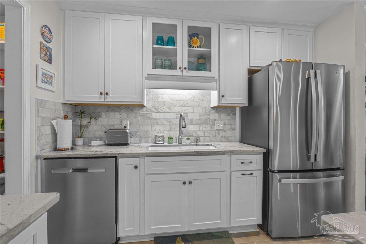 4831 East Olive Road, Unit 1D Pensacola, FL 32514 - Photo 6 of 36 a kitchen with stainless steel appliances granite countertop a refrigerator and a sink