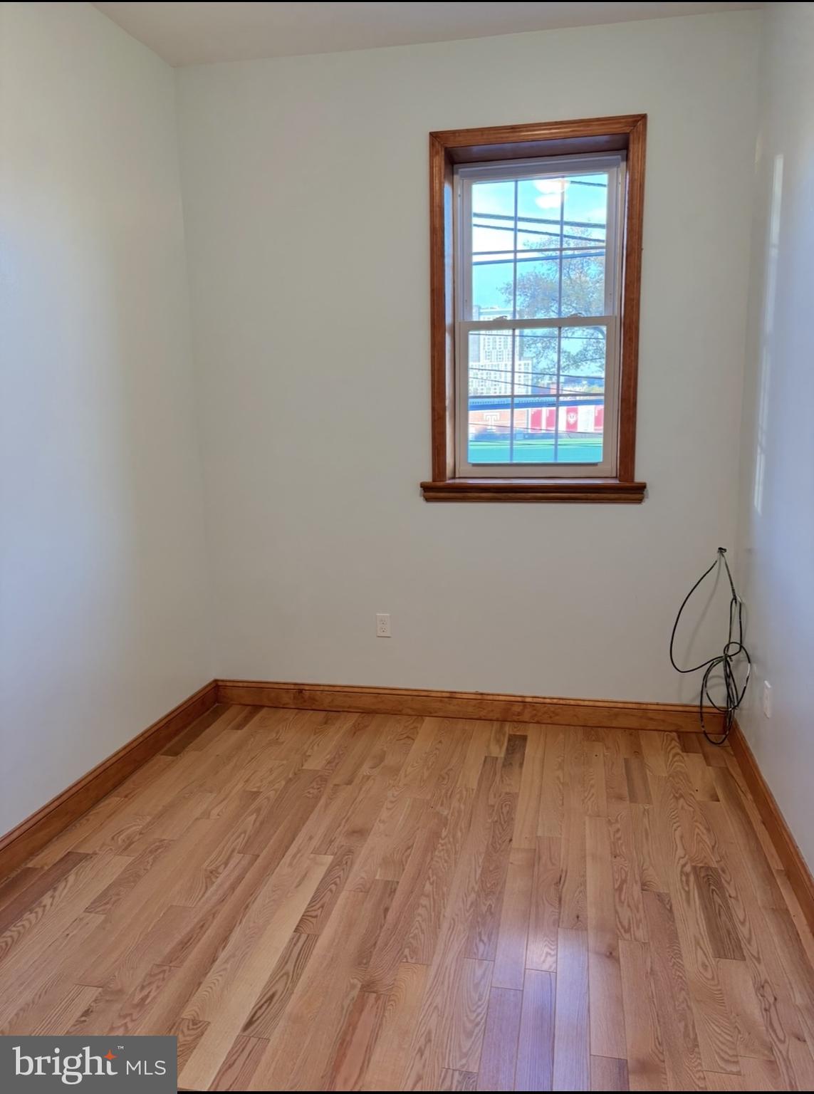 1320 West Girard Avenue, Unit 2ND 1 Philadelphia, PA 19123 - Photo 4 of 6 a view of an empty room with wooden floor and a window
