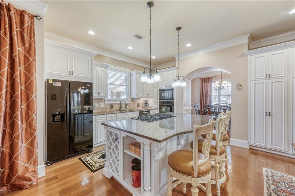2380 Muskogee Lane Braselton, GA 30517 - Photo 10 of 30 a kitchen with stainless steel appliances granite countertop a sink a stove a refrigerator and island