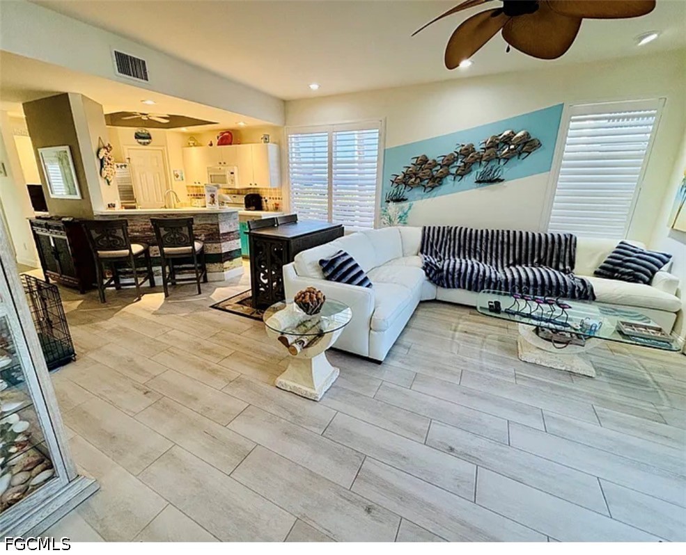 14971 Rivers Edge Court, Unit 101 Fort Myers, FL 33908 - Photo 4 of 15 a living room with furniture and a chandelier