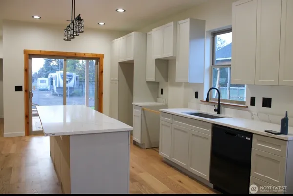 a spacious bathroom with a granite countertop sink a mirror and bathtub