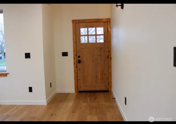 a open kitchen with white cabinets and wooden floor