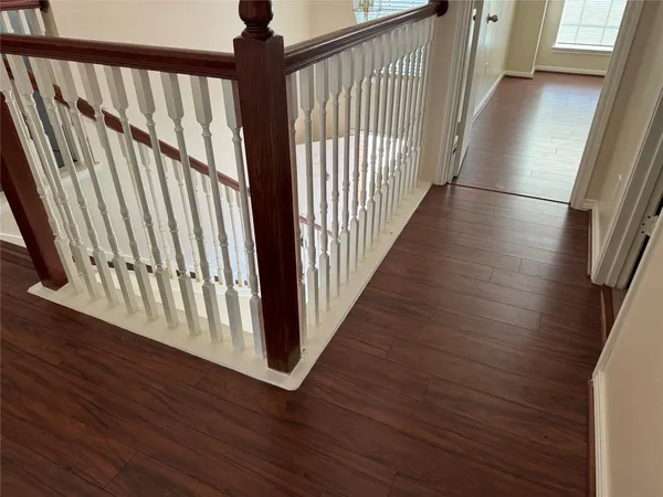 a view of a hallway with wooden floor and staircase